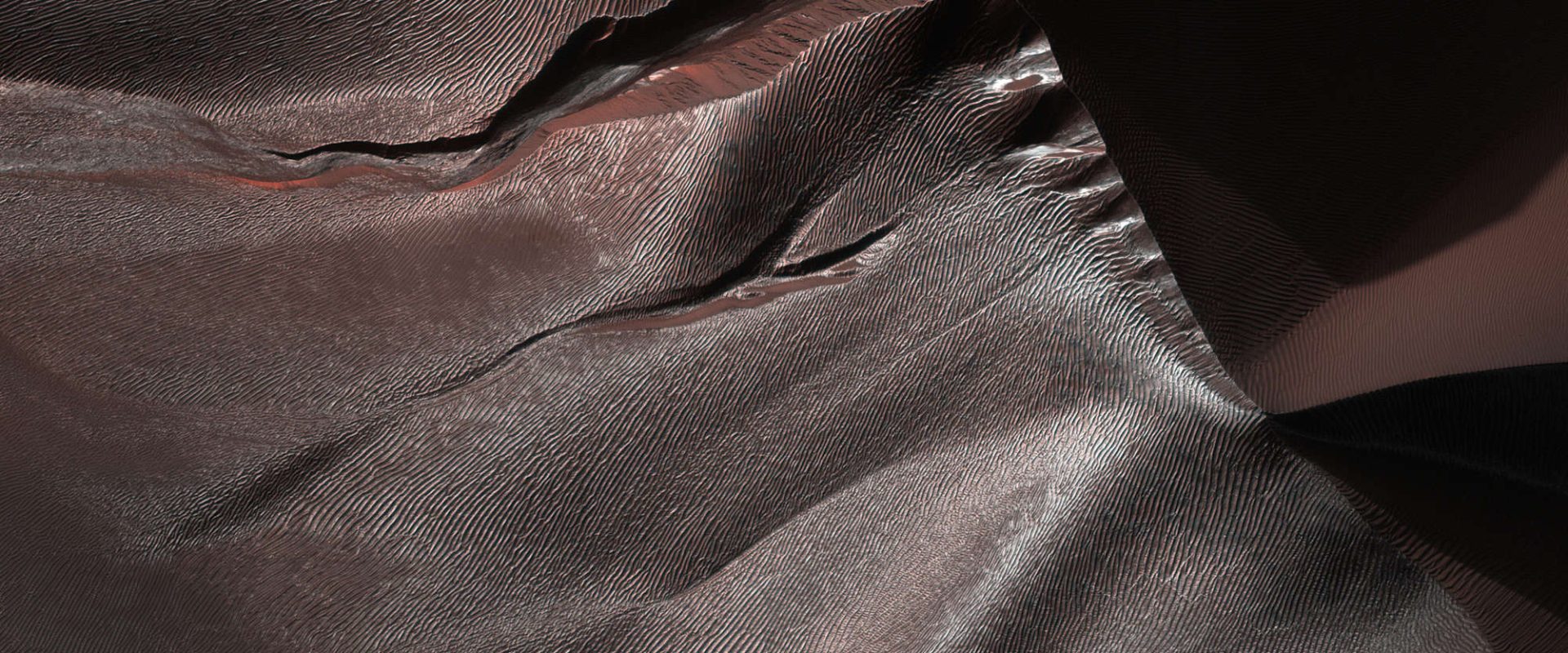 Die Erosion einer großen Sanddüne auf dem Boden eines Mars-Kraters scheint bei saisonalem Frost stattzufinden, nicht bei flüssigem Wasser. Wie das genau funktioniert, bleibt ein Rätsel. © NASA/JPL-Caltech/University of Arizona